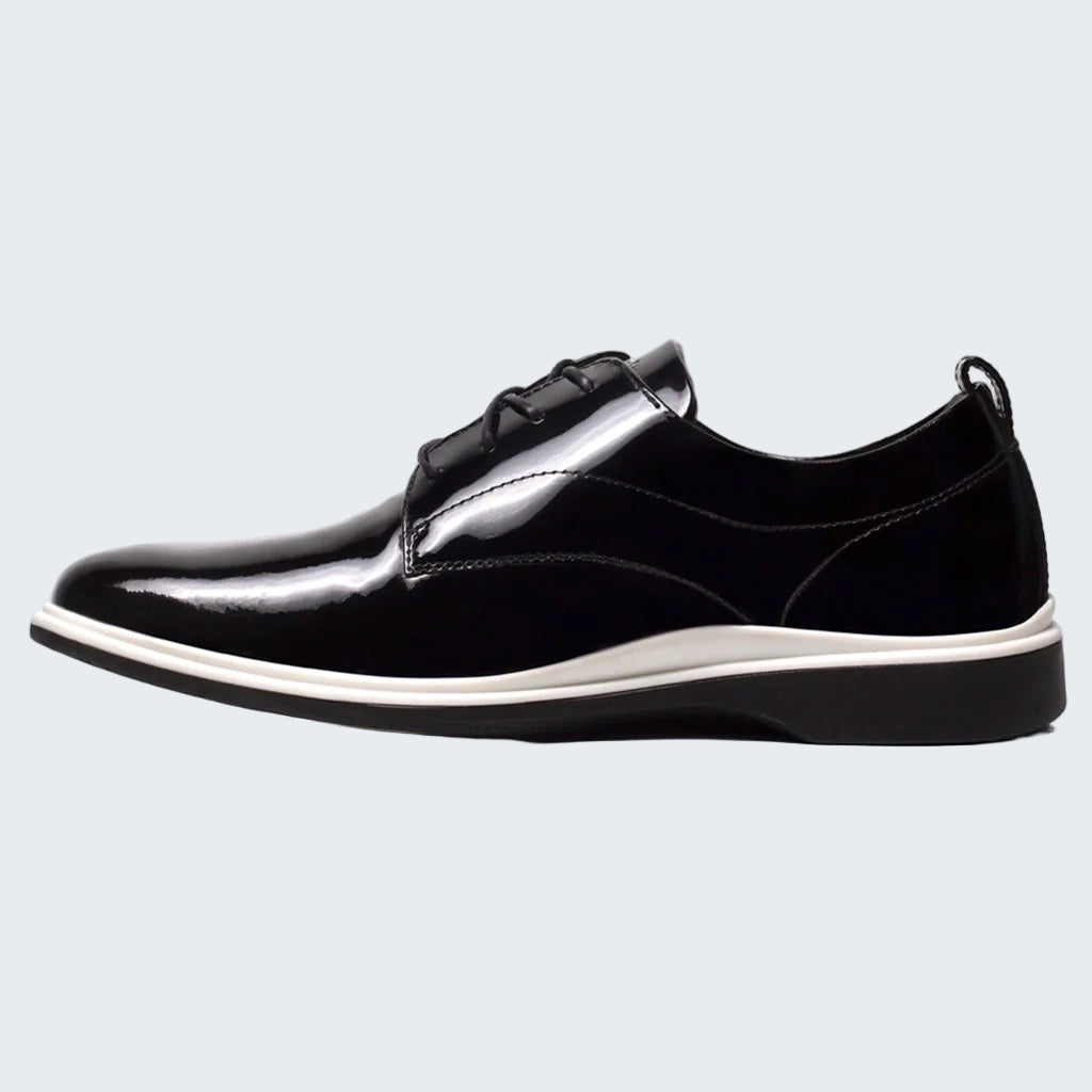 Black leather shoe with a white sole on a white background