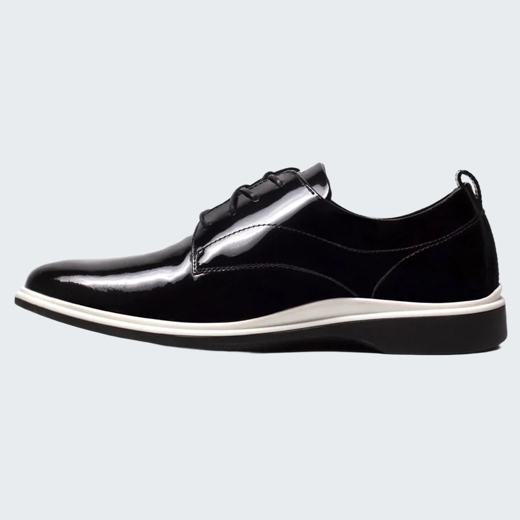 Black leather shoe with a white sole on a white background