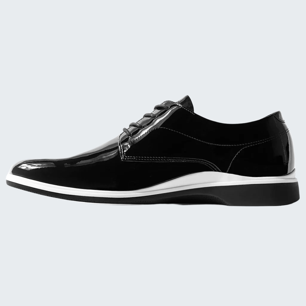 Black patent leather shoe with white sole on a white background