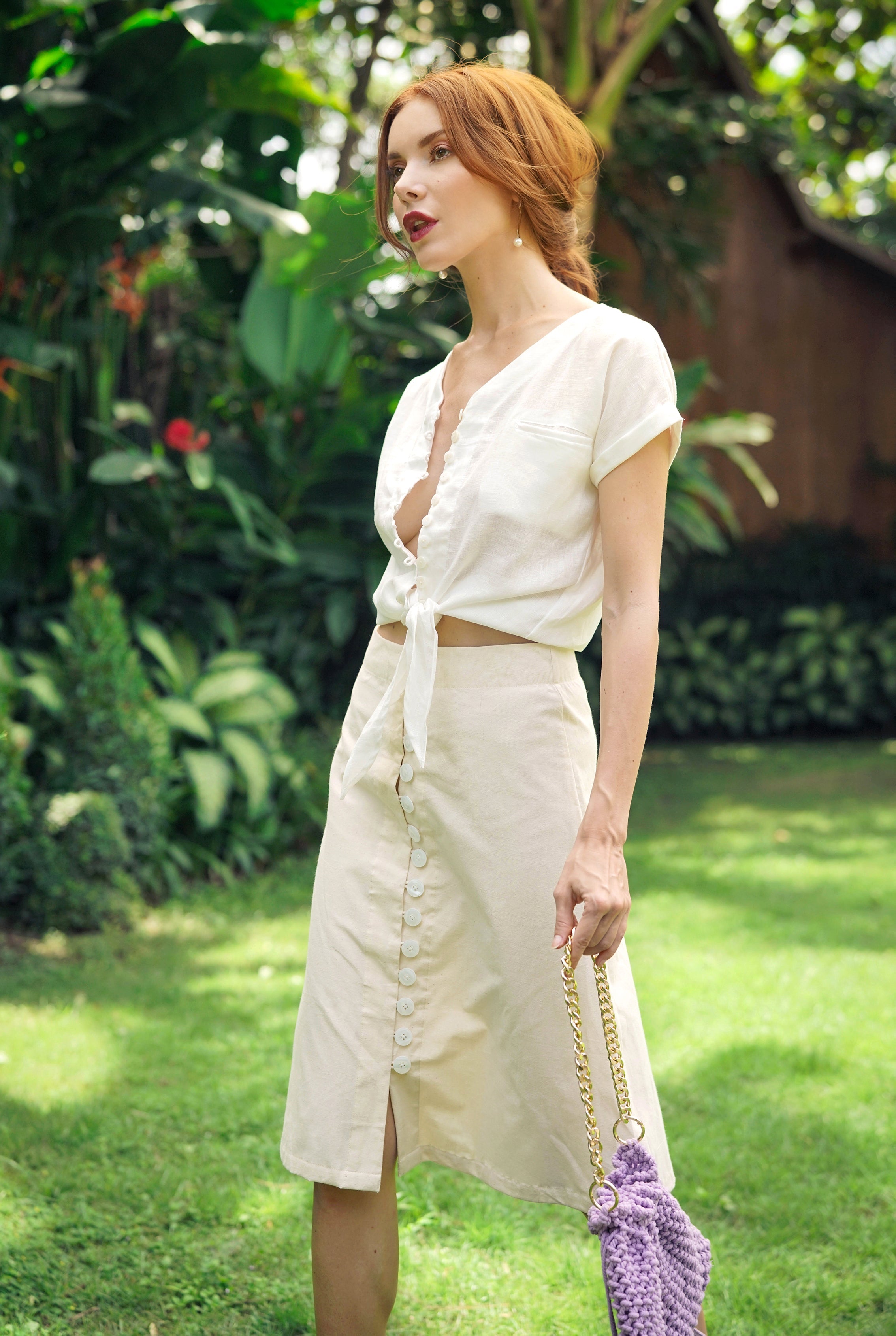 Woman in a white outfit standing in a garden