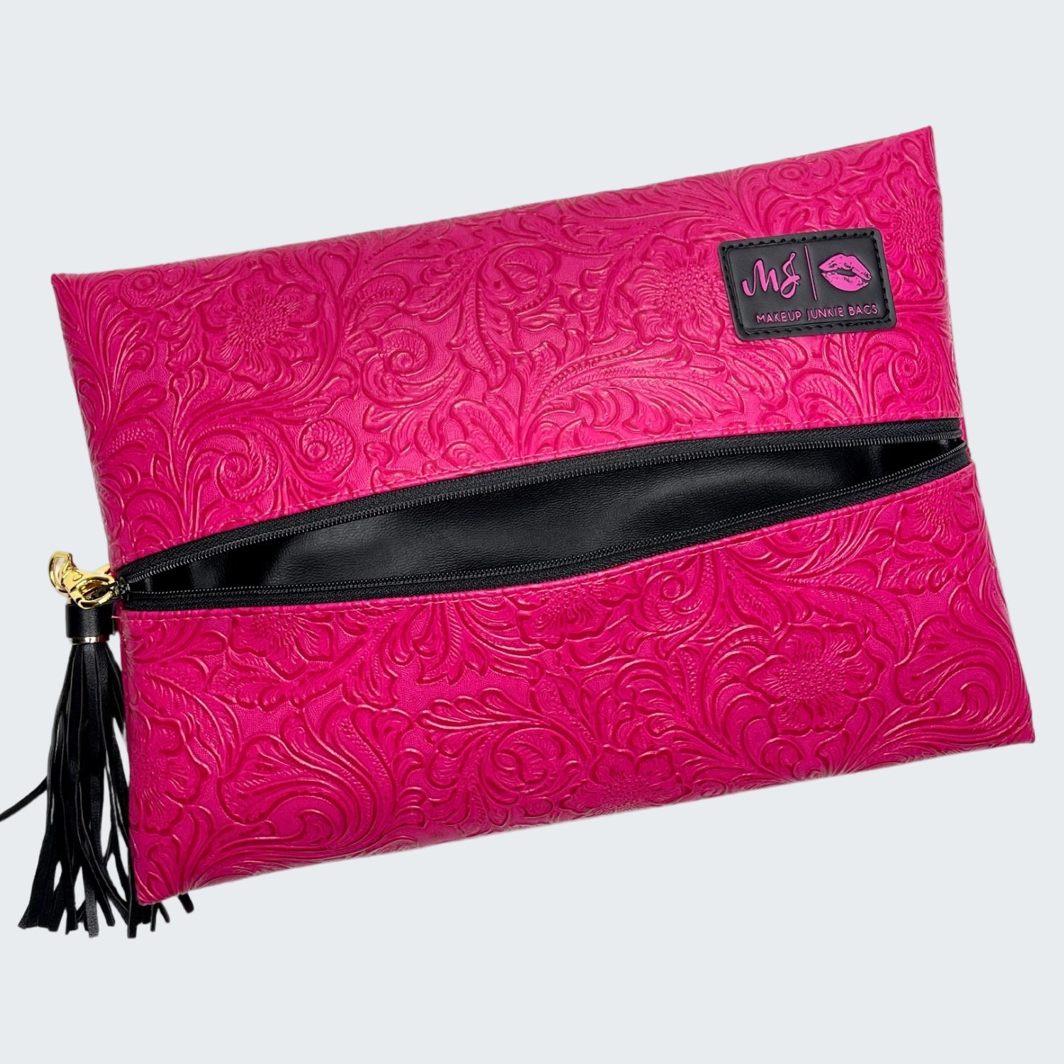 Pink clutch bag with black zipper and tassel on a white background