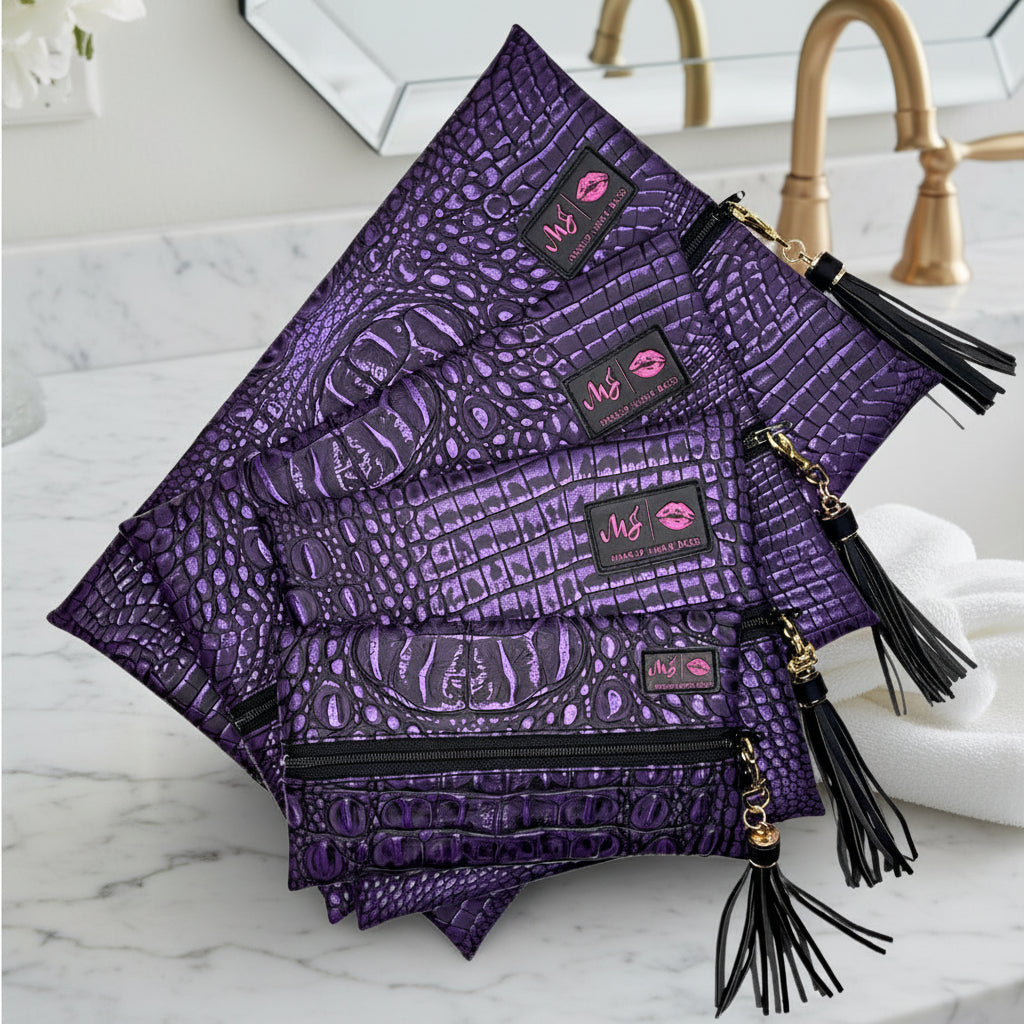 Set of purple patterned pouches with tassels on a white background