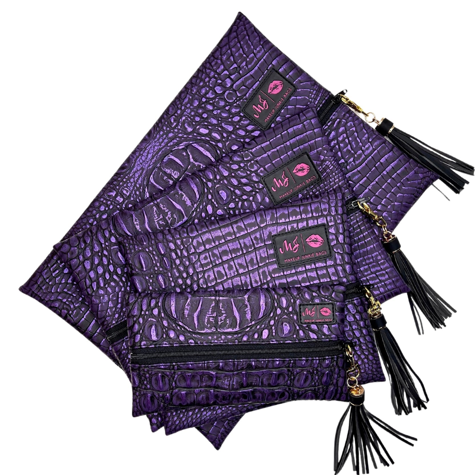 Set of purple patterned pouches with tassels on a white background