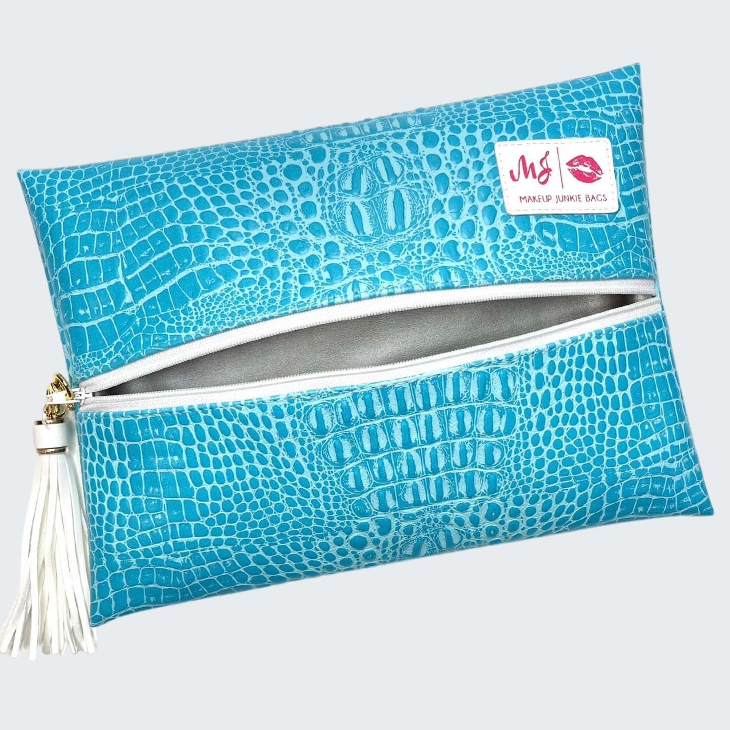 Blue crocodile pattern makeup bag with a white zipper and tassel on a white background