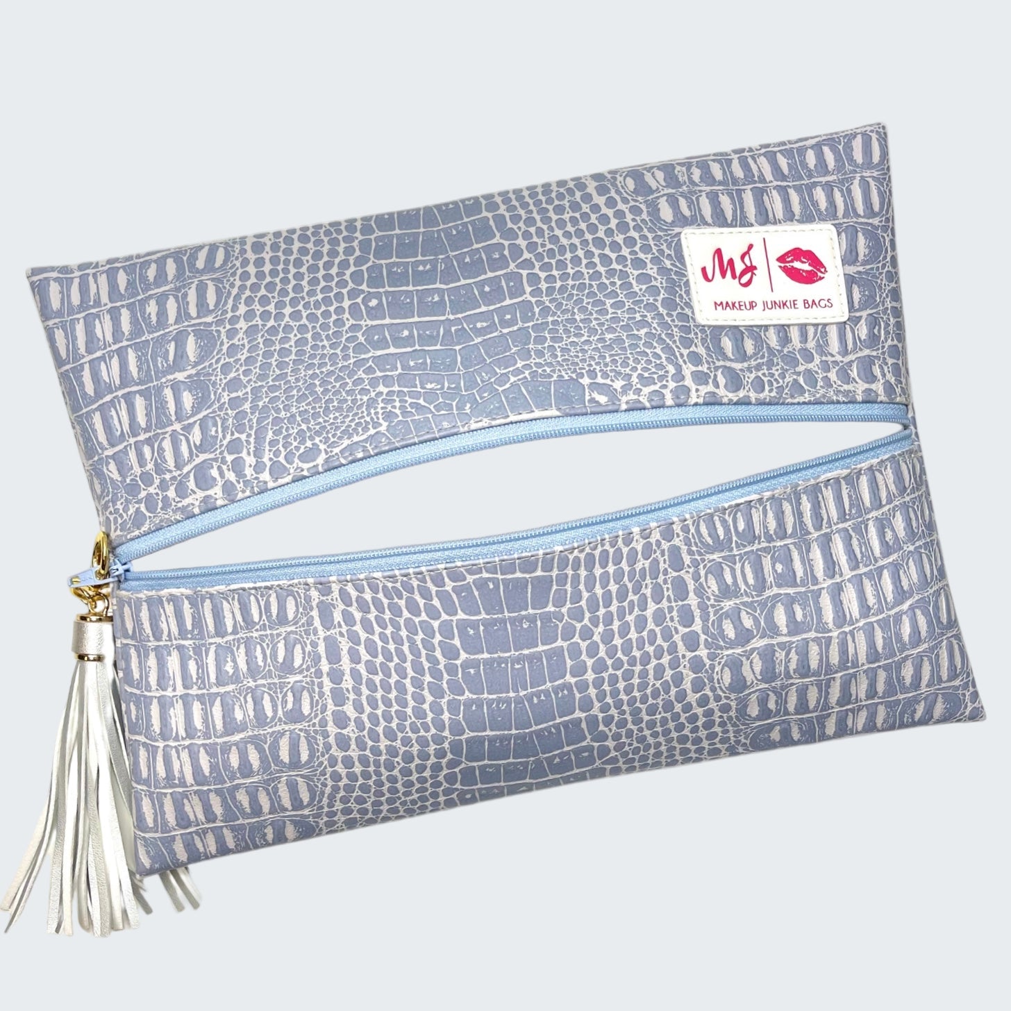 Blue crocodile-patterned makeup bag with a visible brand logo on a white background