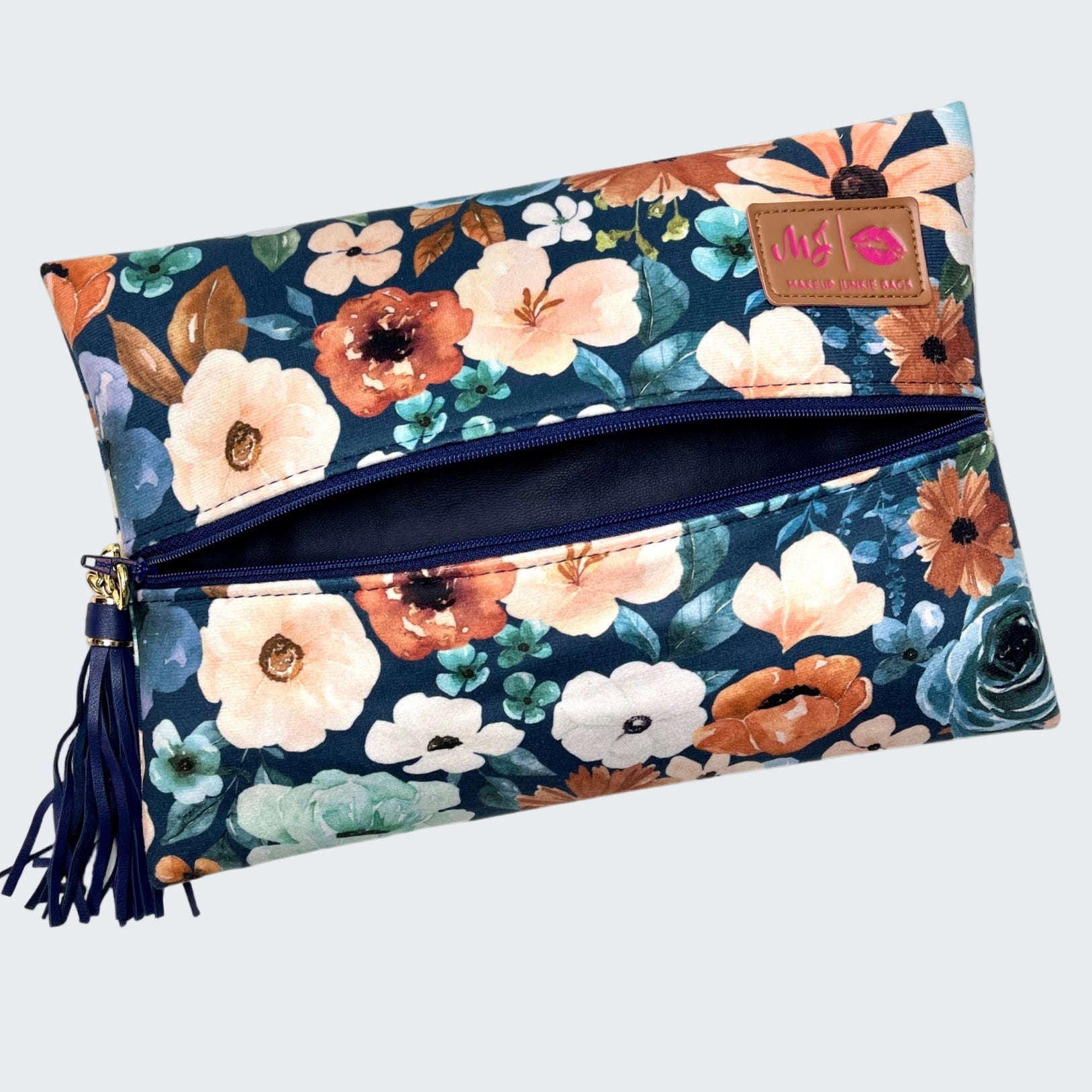 Floral patterned clutch bag with a tassel on a white background