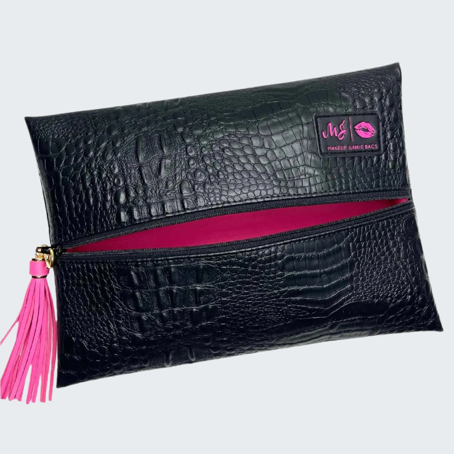 Black crocodile-patterned clutch bag with pink zipper and tassel on a white background