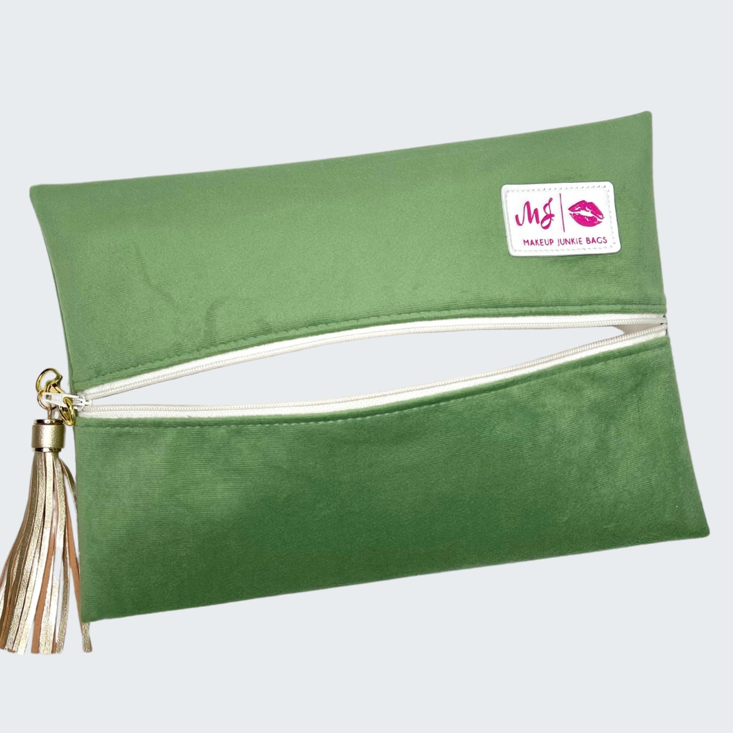 Green makeup bag with a tassel on a white background