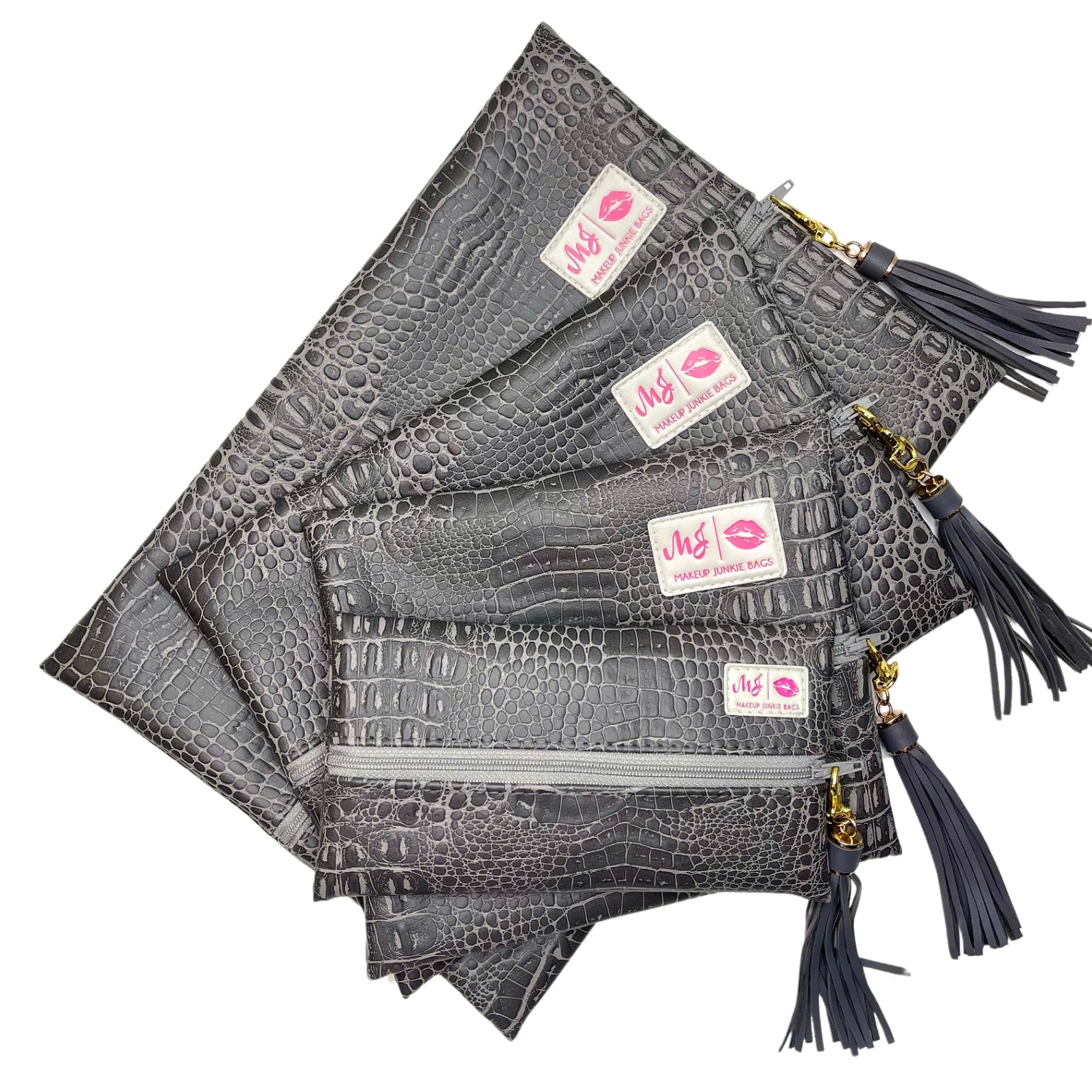 Gray crocodile-patterned pouches with tassels and visible brand labels on a white background