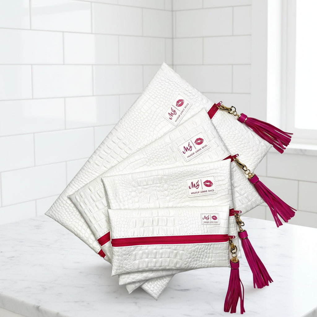 Set of white makeup bags with red zippers and tassels on a white background