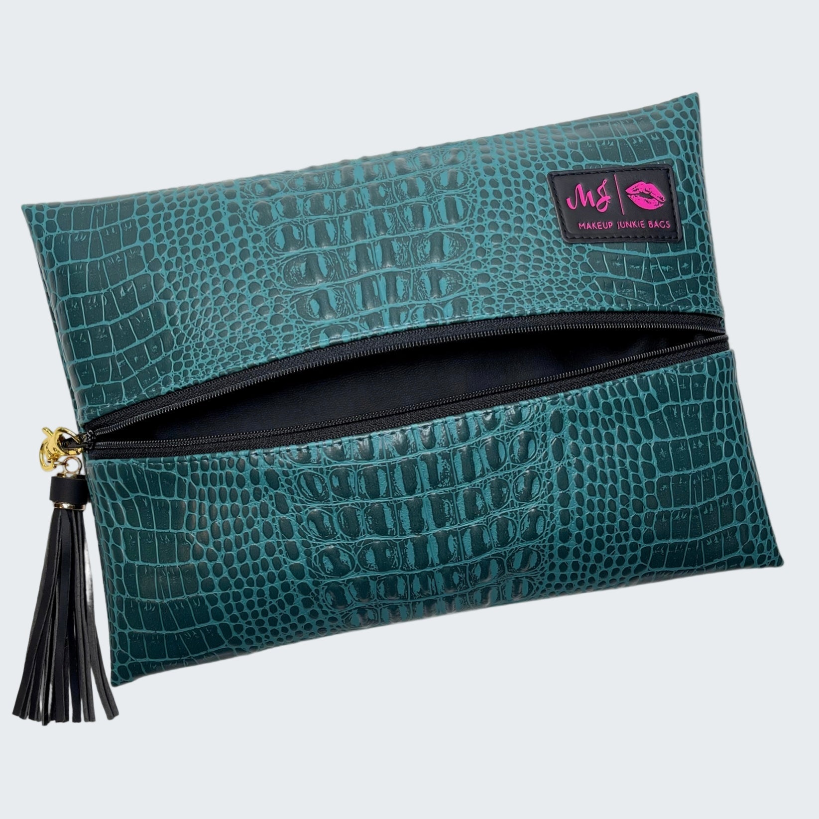 Teal crocodile-patterned pouch with a tassel on a white background