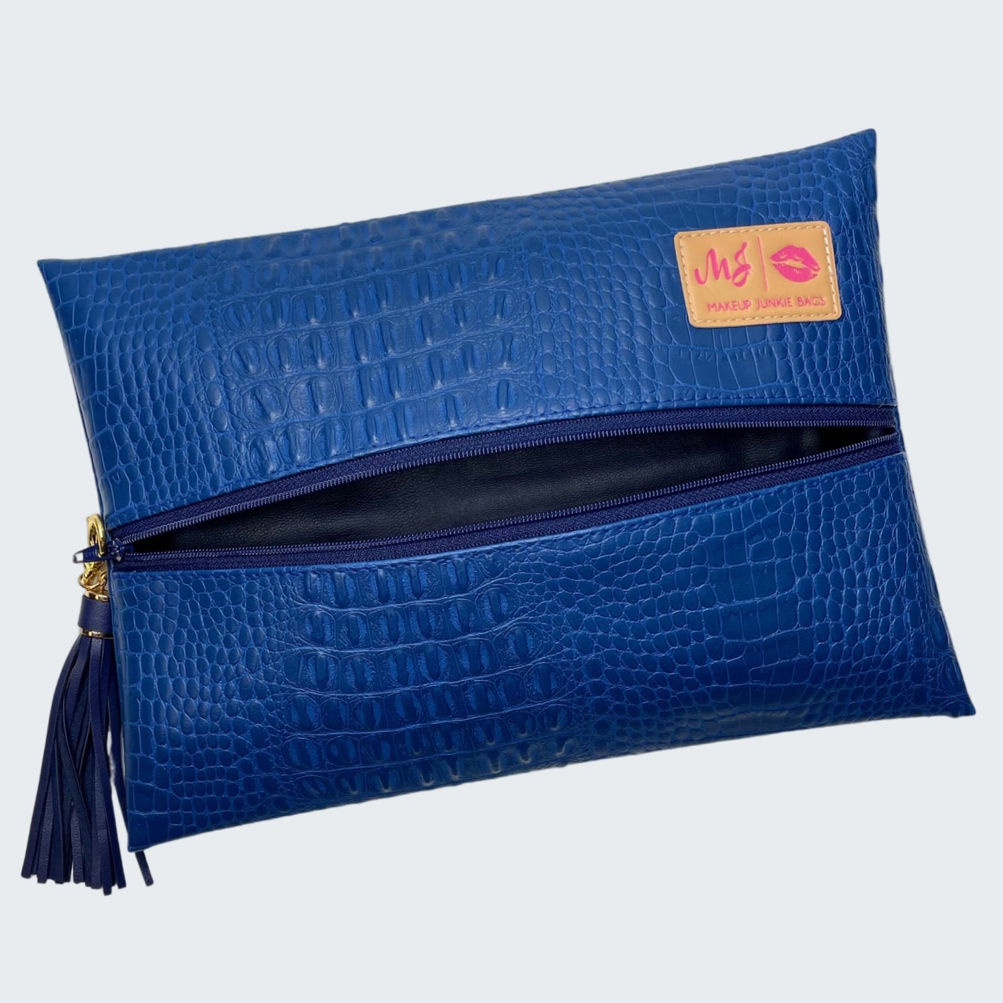 Blue crocodile-textured clutch bag with a visible brand label on a white background