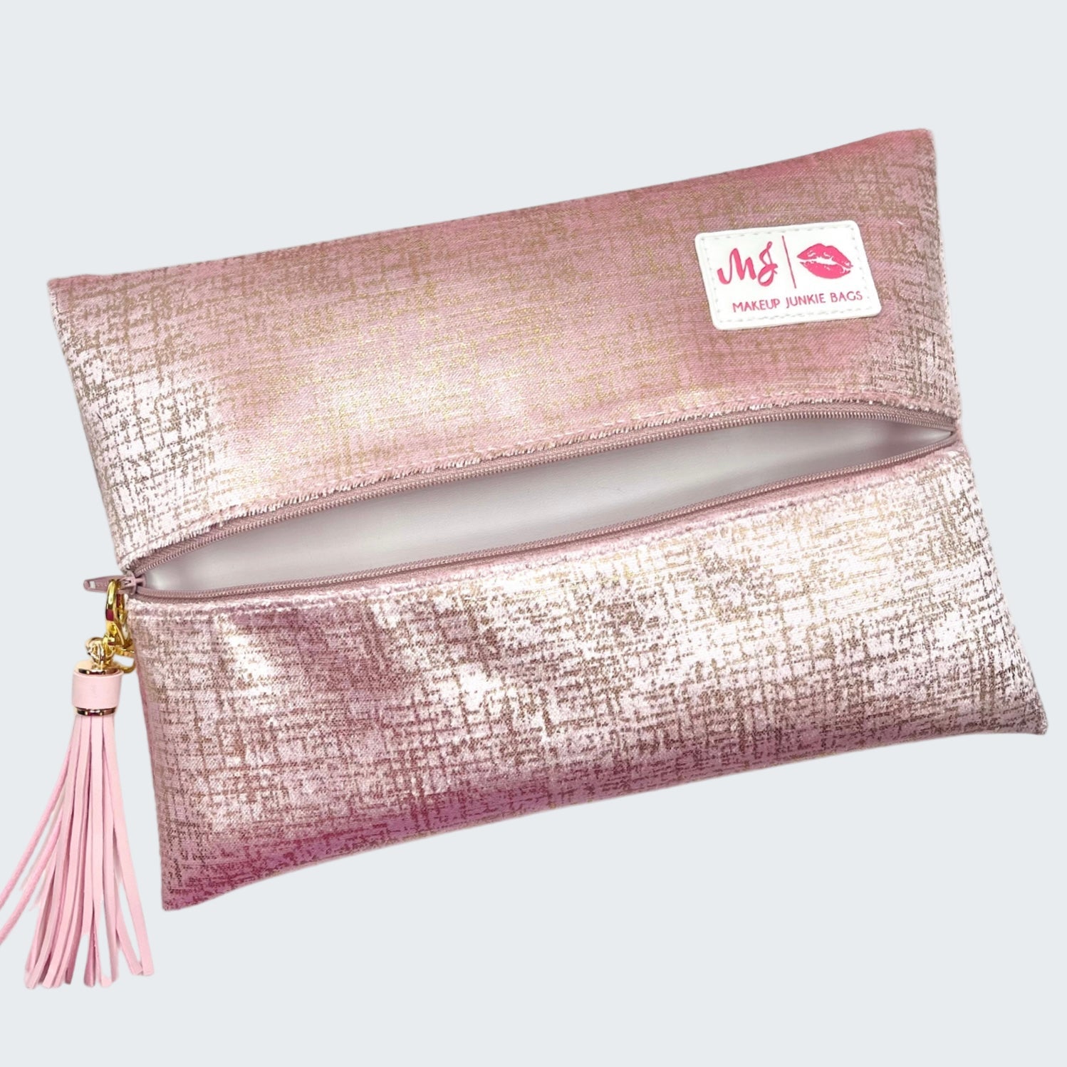 Pink makeup bag with a tassel on a white background