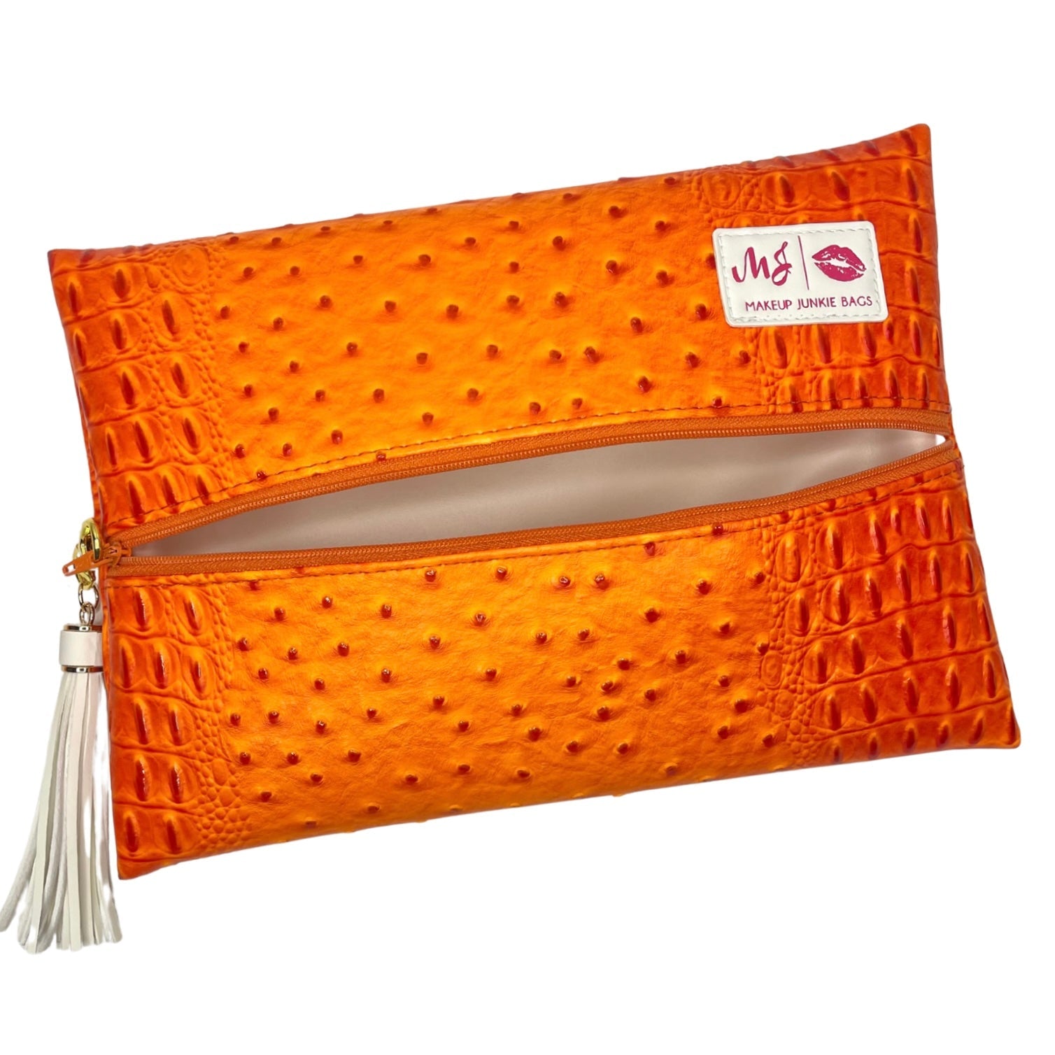 Orange textured clutch bag with a tassel on a white background