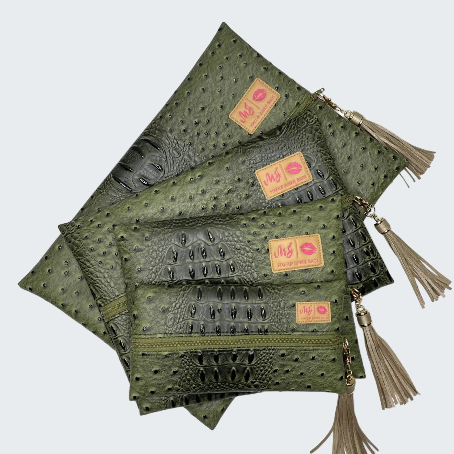 Set of green leather pouches with tassels on a white background