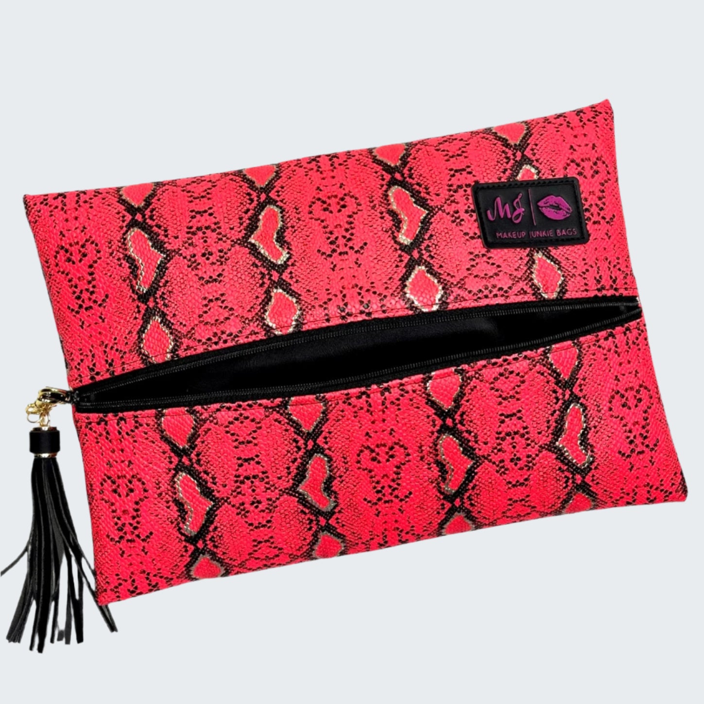 Pink snakeskin patterned clutch bag with a black zipper and tassel on a white background