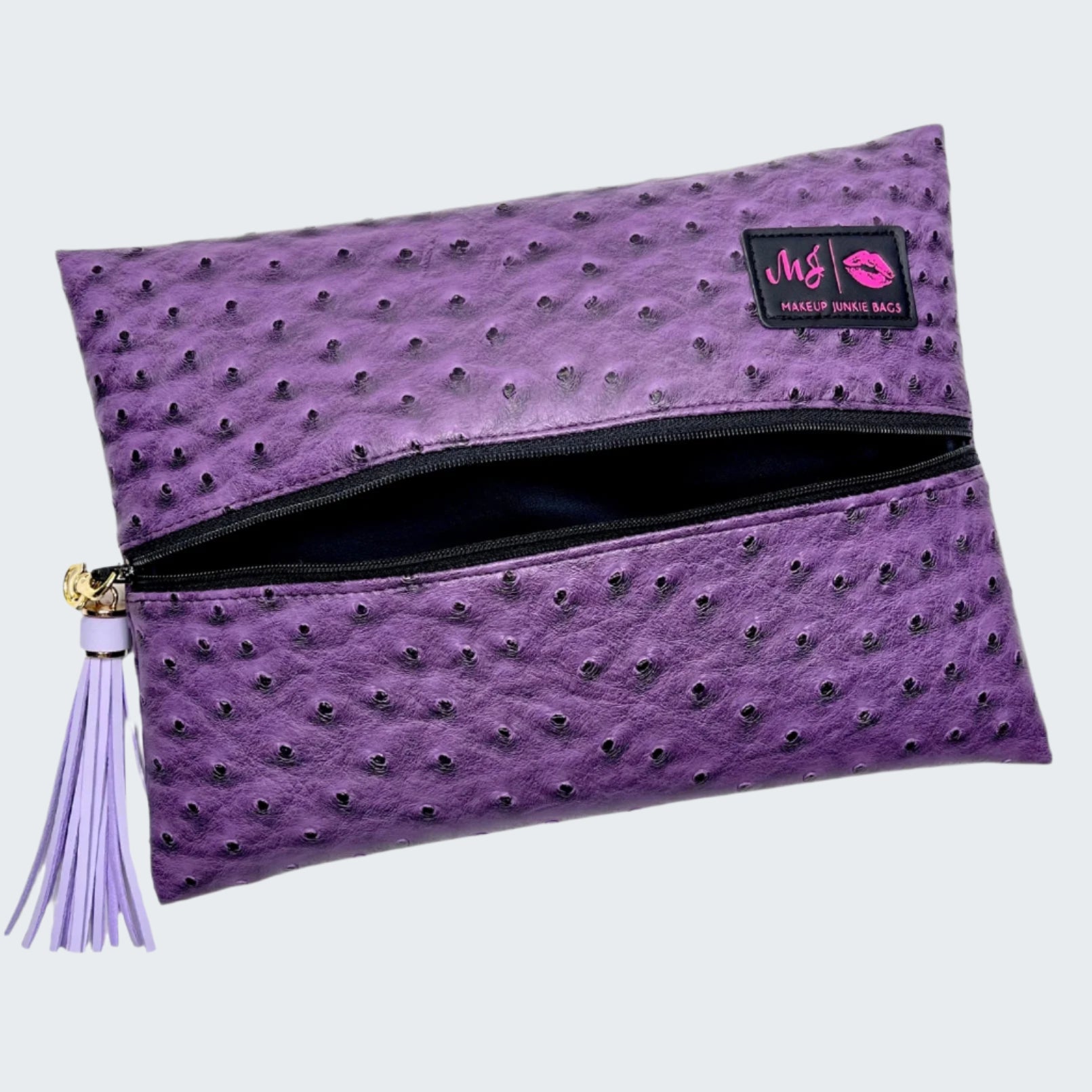 Purple textured clutch bag with a tassel on a white background