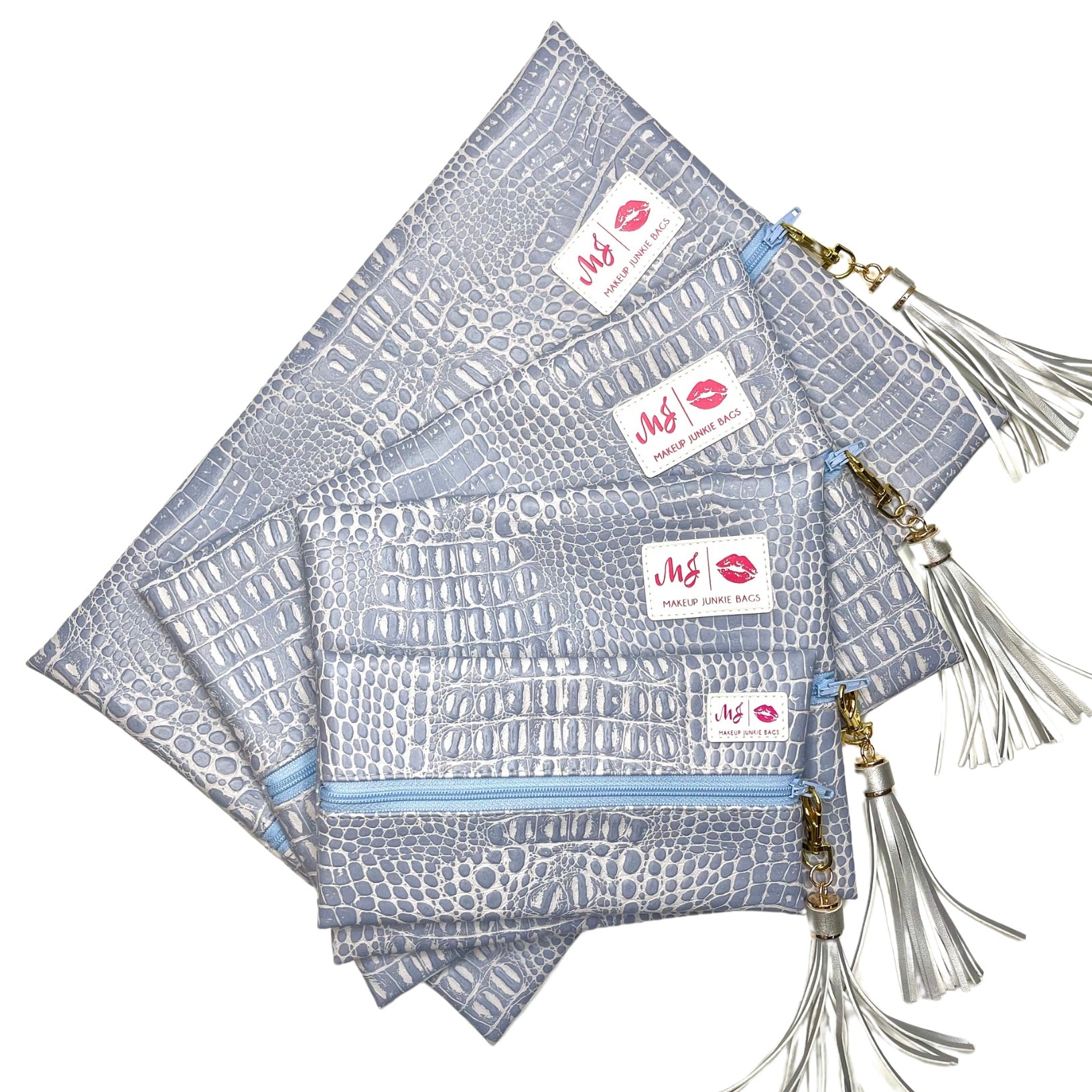 Set of gray patterned pouches with tassels and visible brand labels on a white background