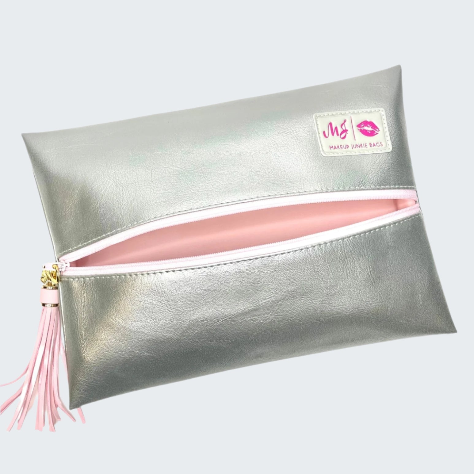 Silver clutch with pink interior and tassel on a white background