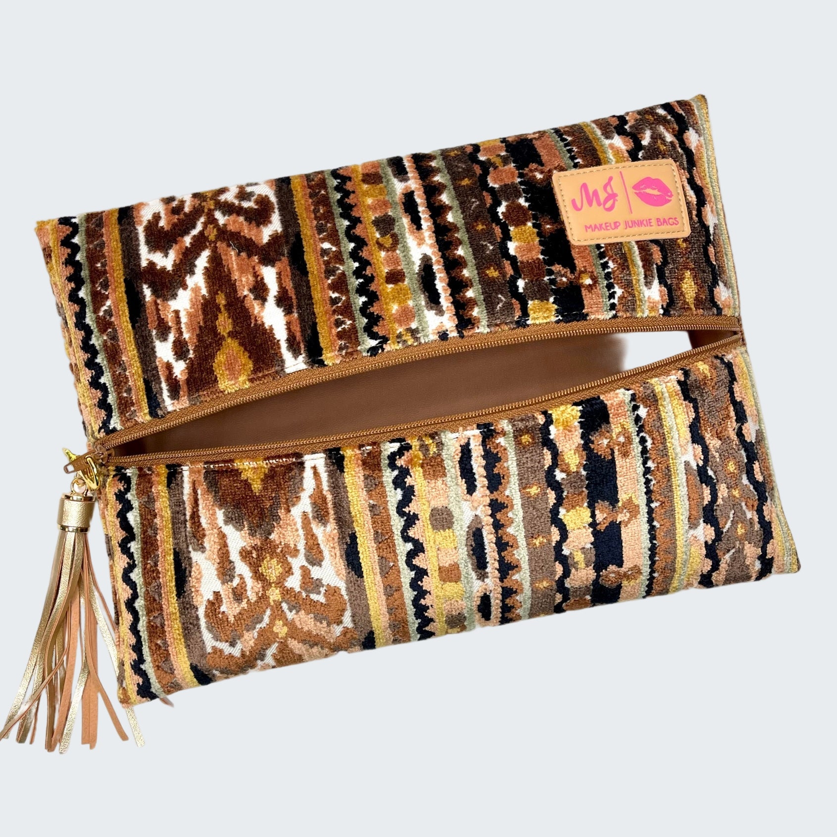 Patterned clutch bag with tassel on a white background