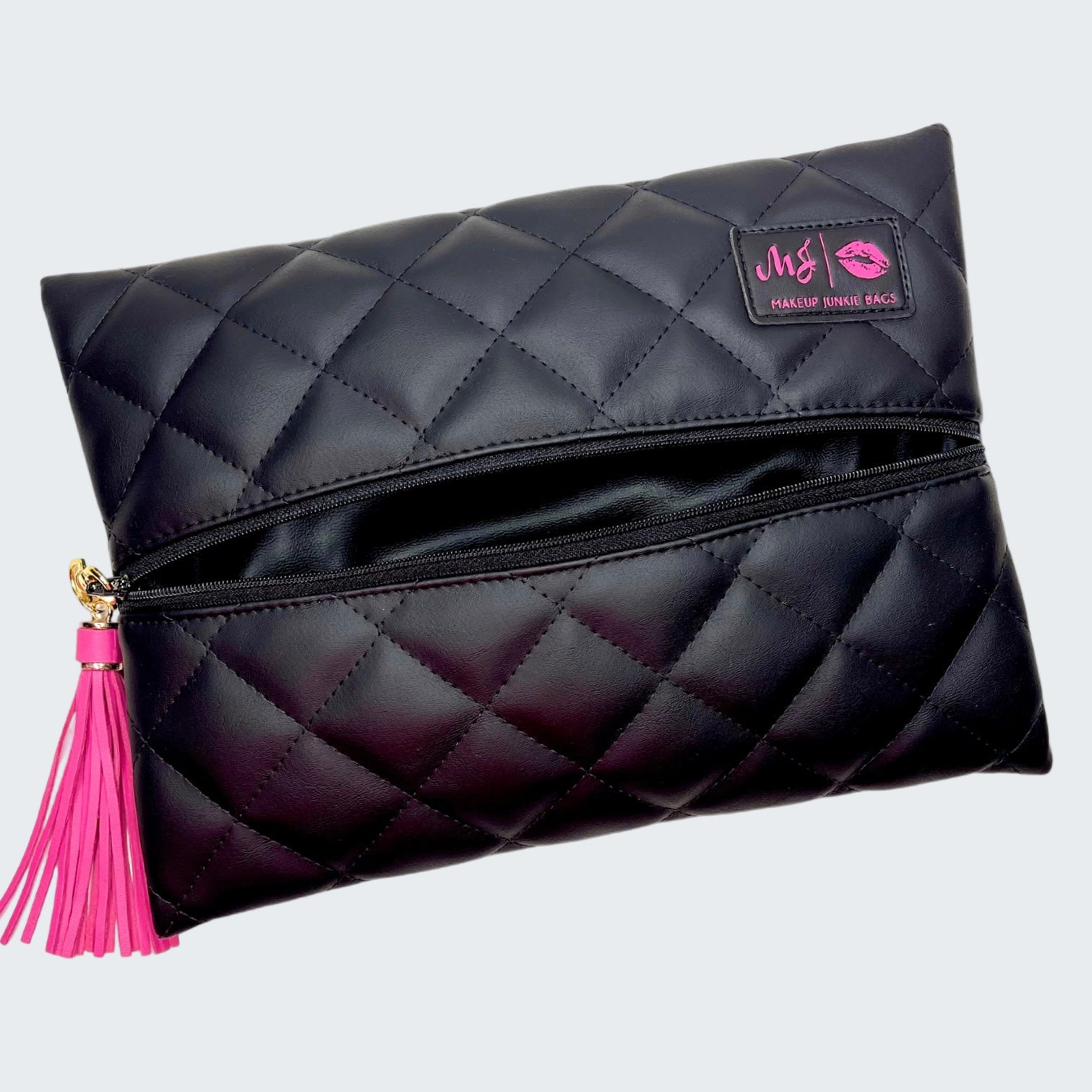 Black quilted makeup bag with pink tassel and visible brand logo on a white background