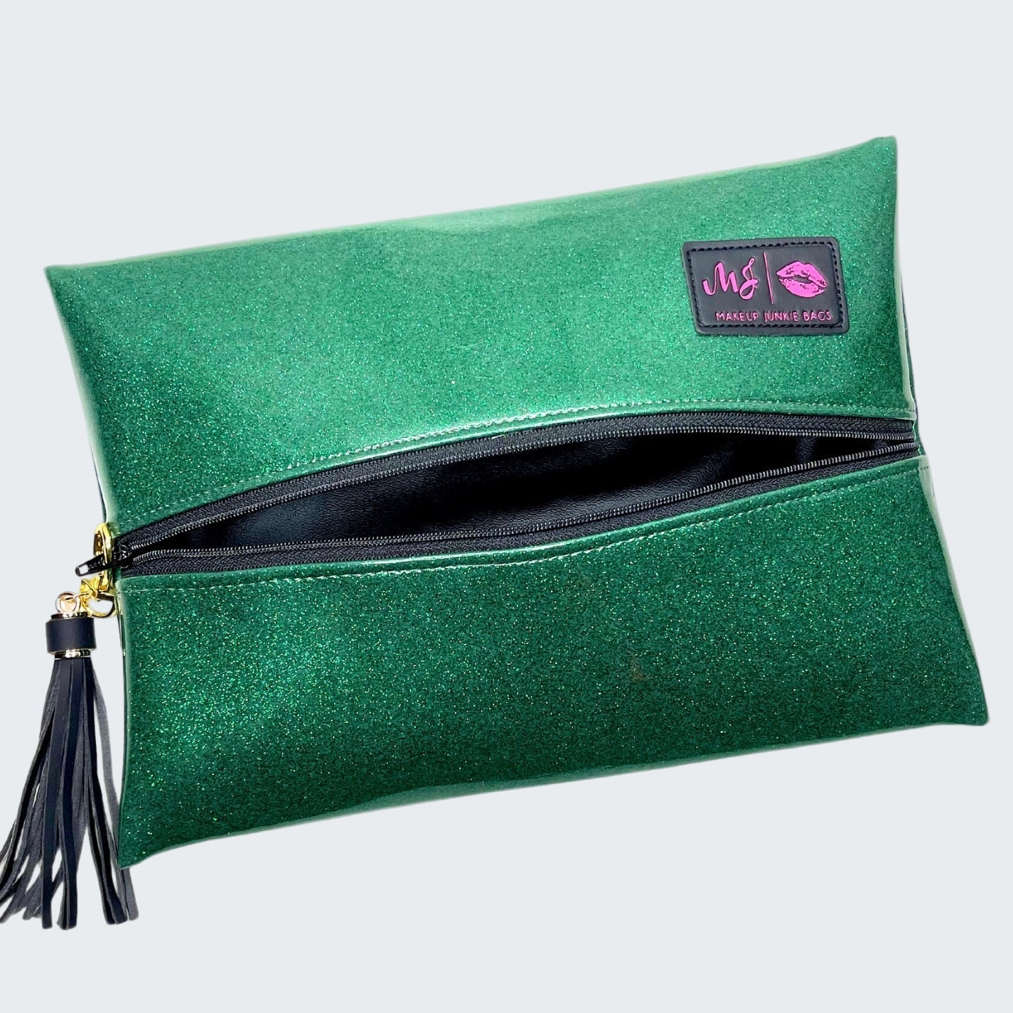 Green glittery clutch bag with a tassel on a white background
