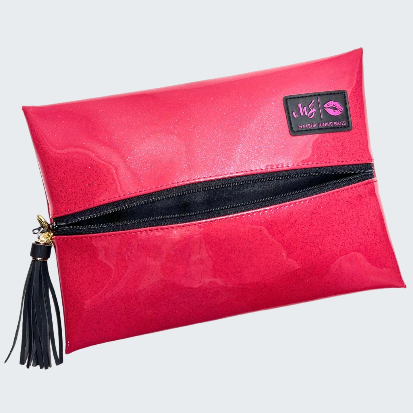 Pink makeup bag with black zipper and tassel on a white background