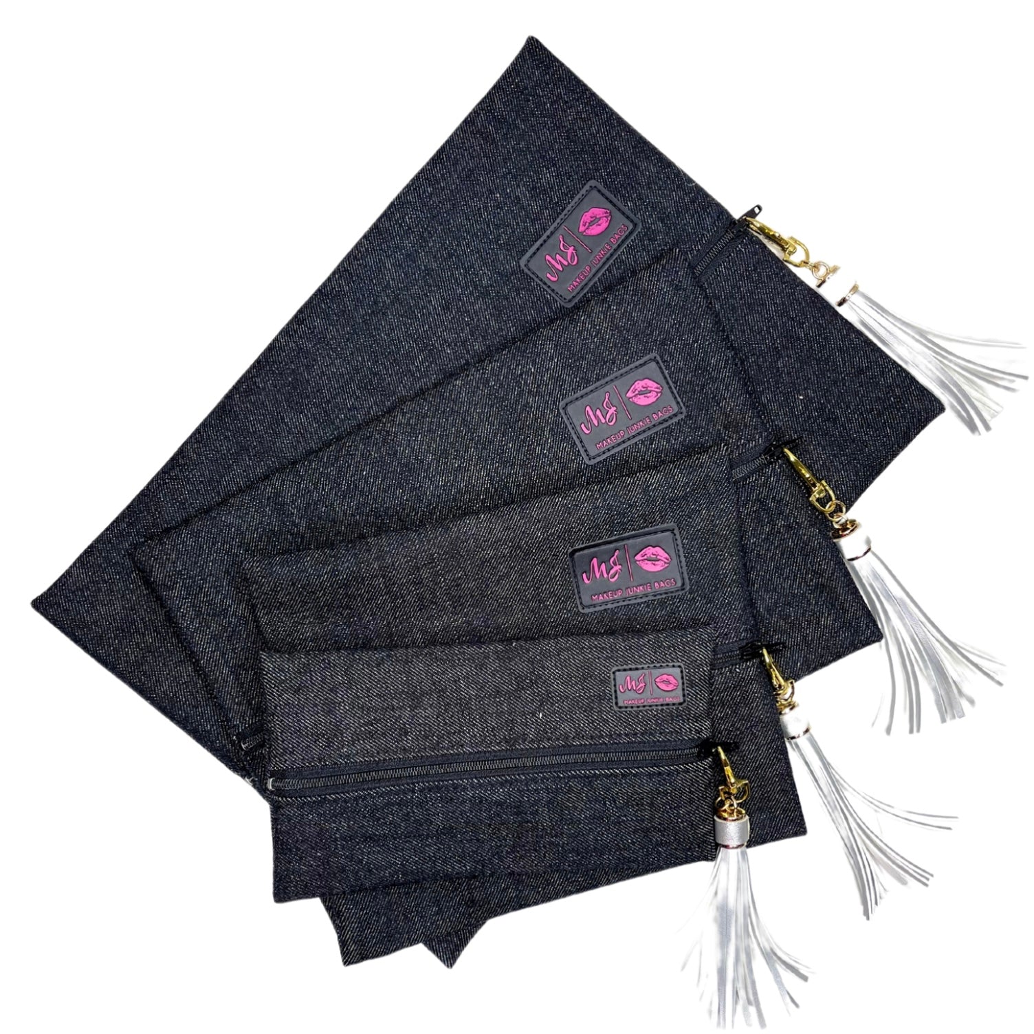 Set of dark denim pouches with gold zippers and white tassels on a white background