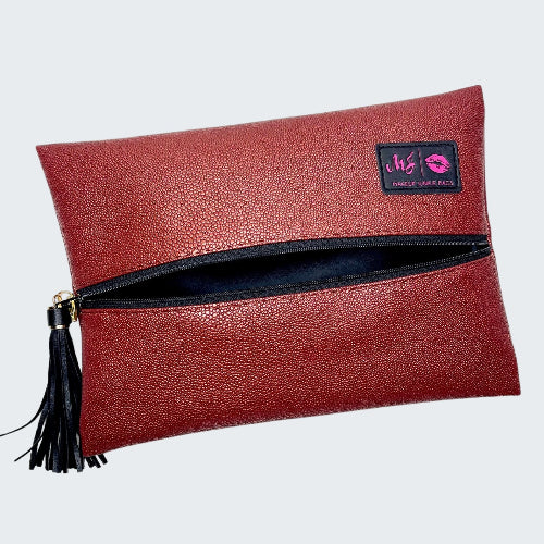 Red clutch bag with a tassel and visible brand logo on a white background