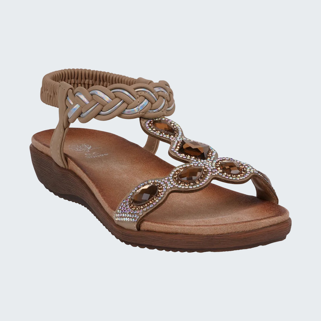 Brown sandal with braided strap and embellishments on a white background