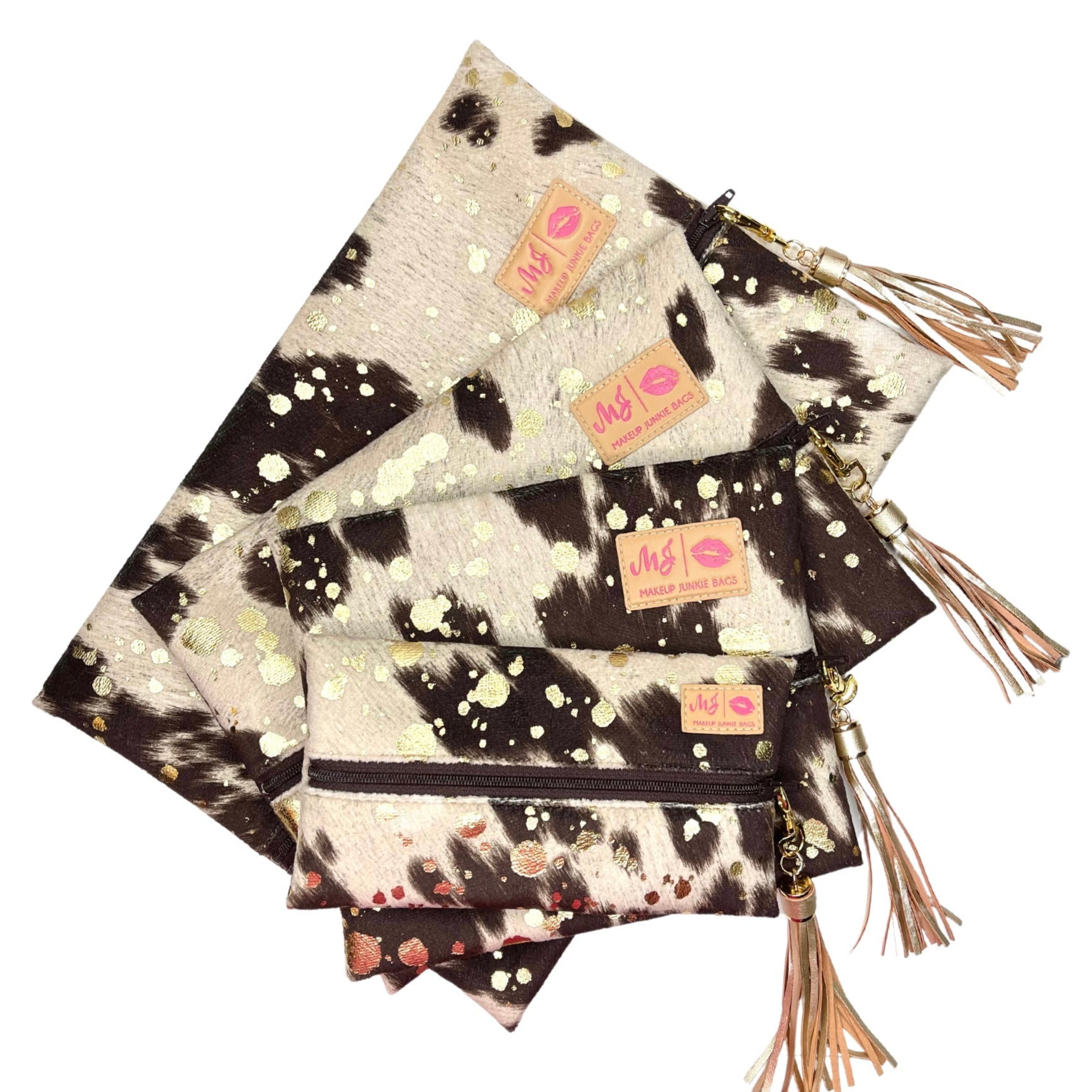 Set of cow print pouches with tassels on a white background