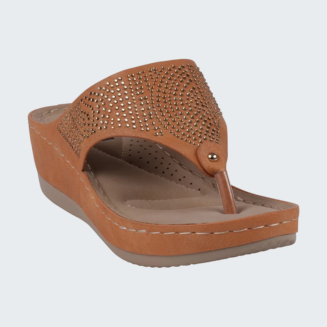 Brown wedge sandal with embellishments on a white background