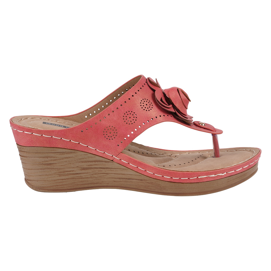 Coral wedge sandal with a flower detail on a white background