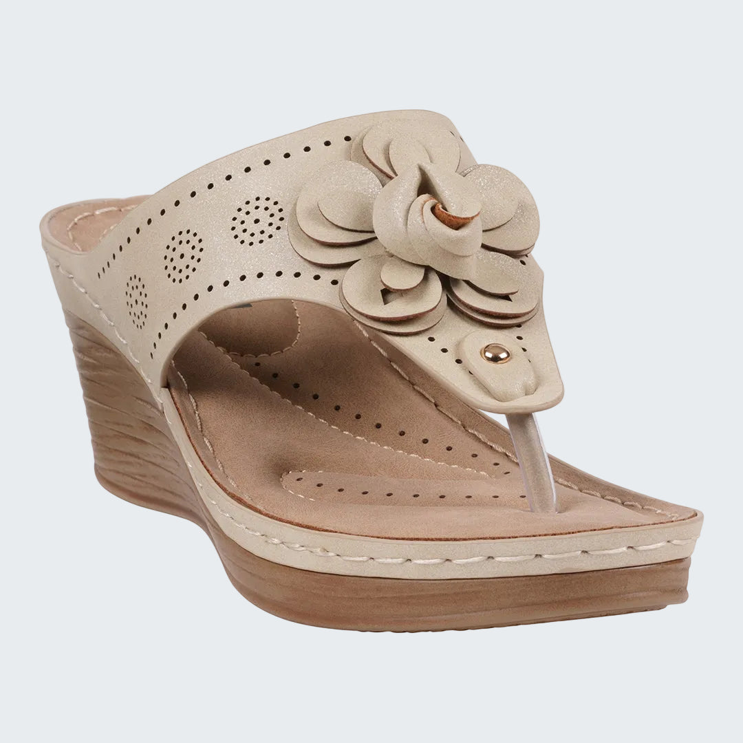 Beige wedge sandal with floral design on a white background