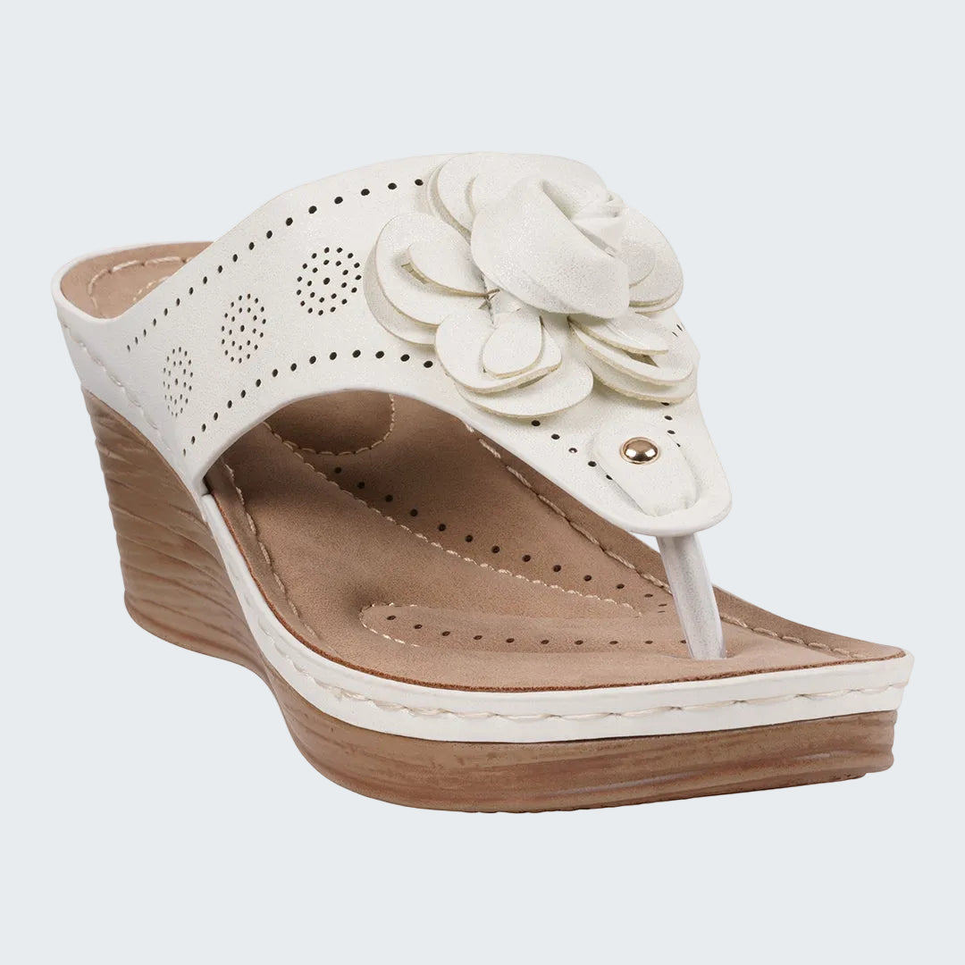White wedge sandal with floral design on a white background