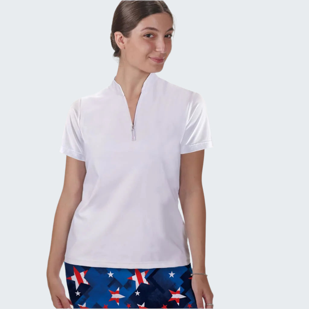 Woman wearing a white polo shirt and blue shorts with star pattern on a plain background