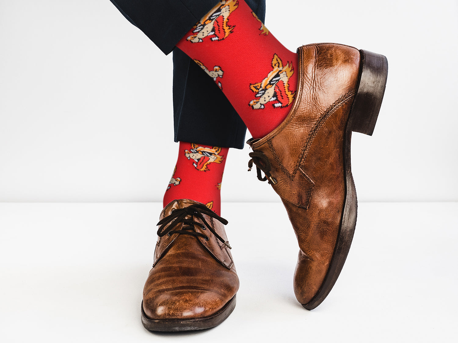 Brown dress shoes and red socks with cartoon design on a white background