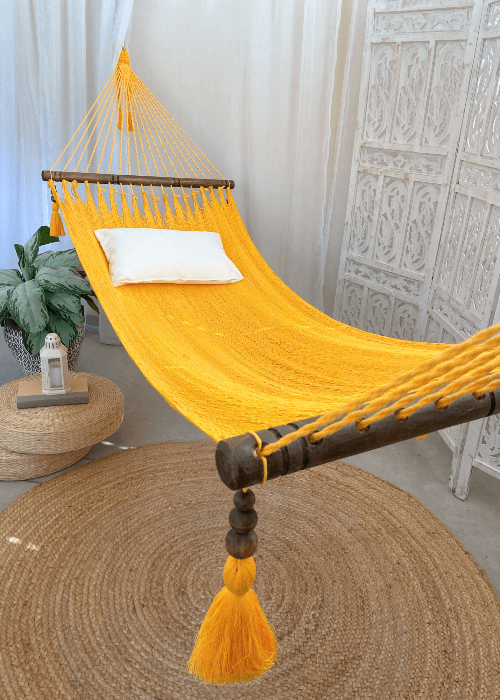 Yellow hammock with wooden accents in a room setting