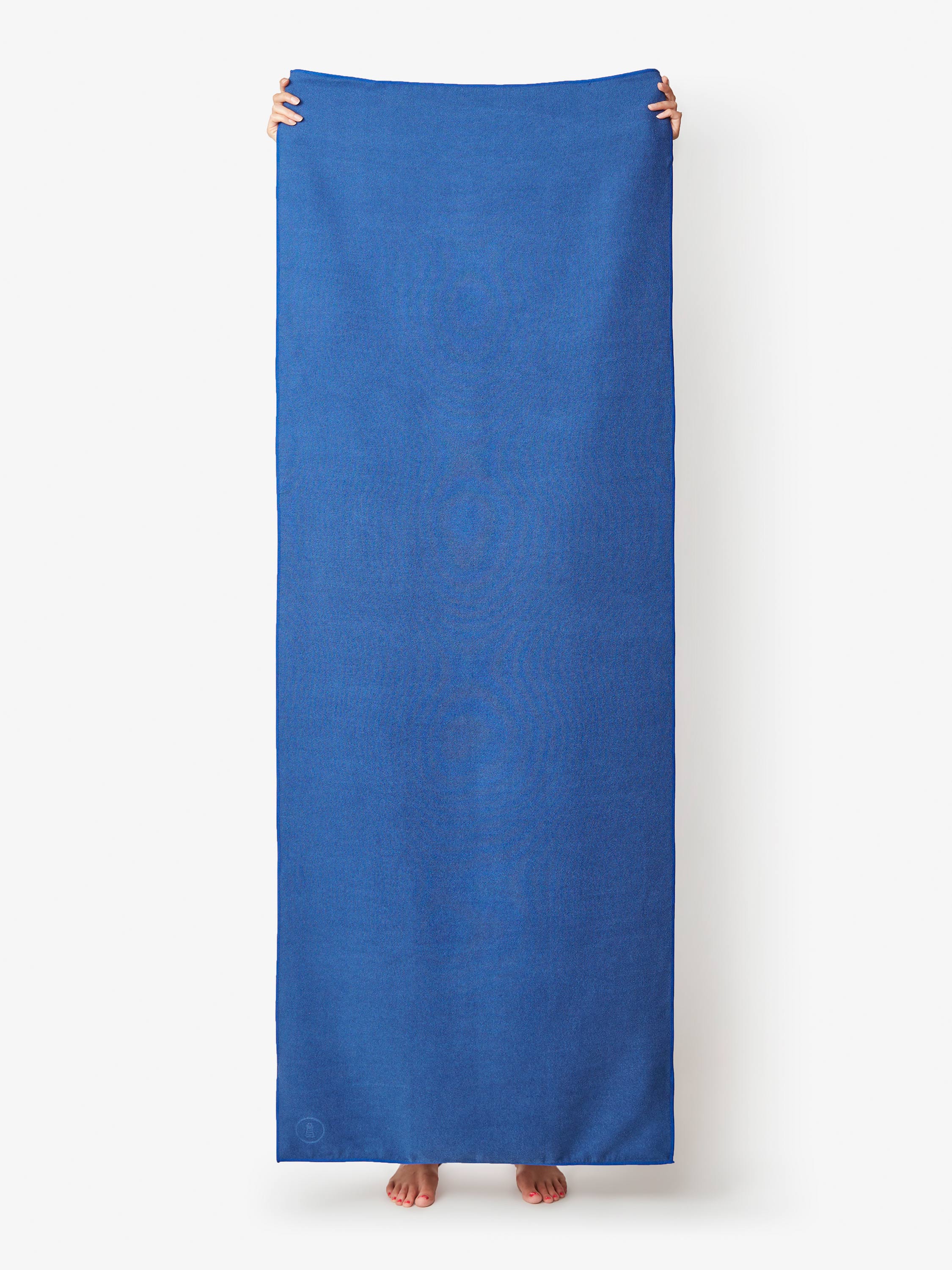 Person holding a long blue towel against a white background