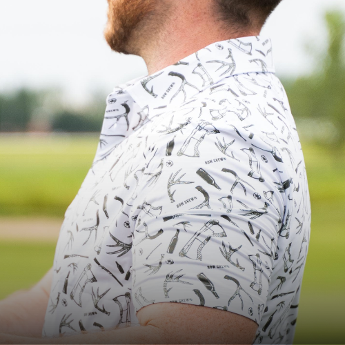 Person wearing a white shirt with black patterns in an outdoor setting