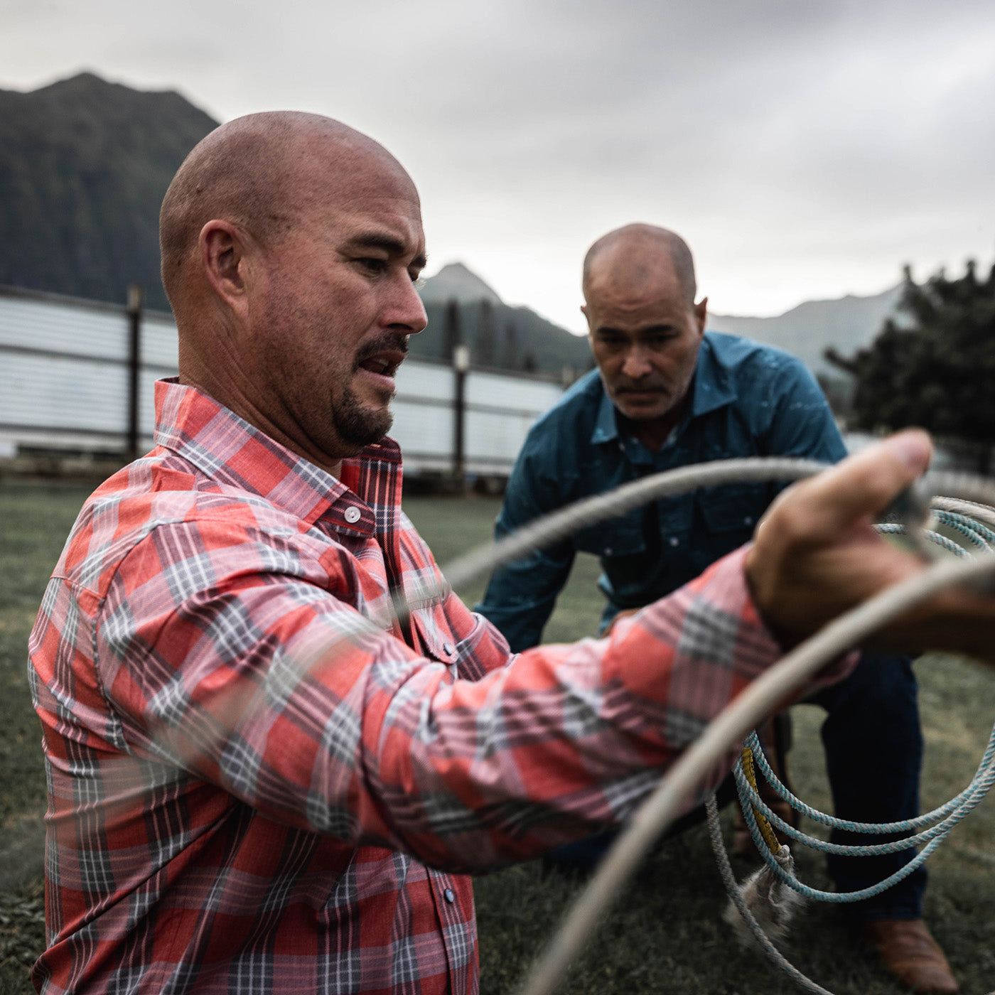 Two men working with rope in an outdoor setting