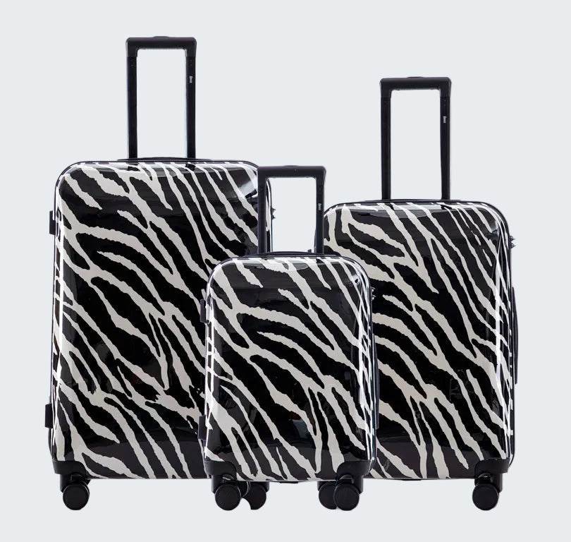 Set of three zebra-patterned suitcases on a white background