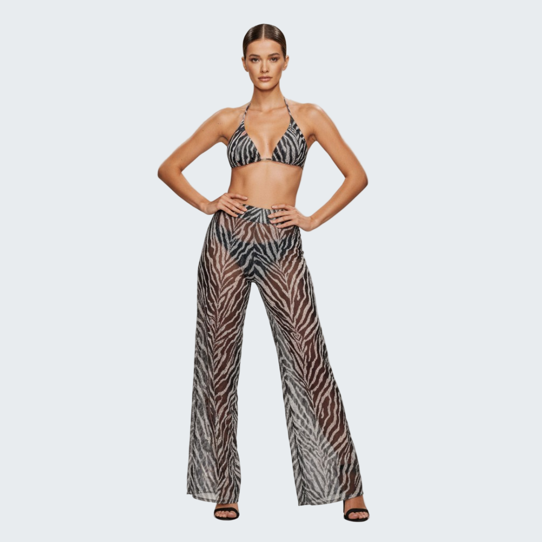 Model wearing a zebra print bikini and pants on a gray background