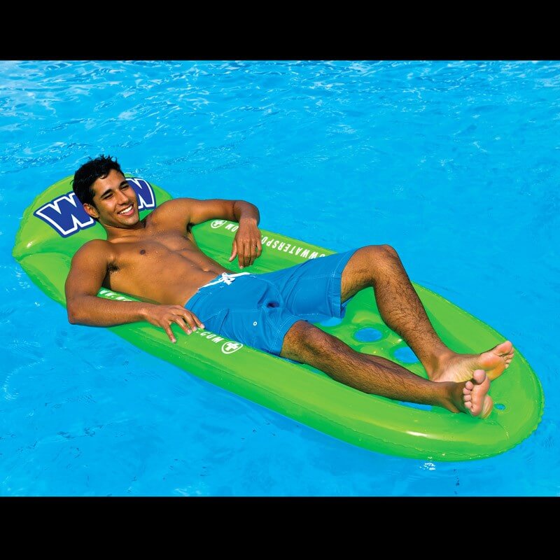Man lying on a green inflatable pool float in a swimming pool