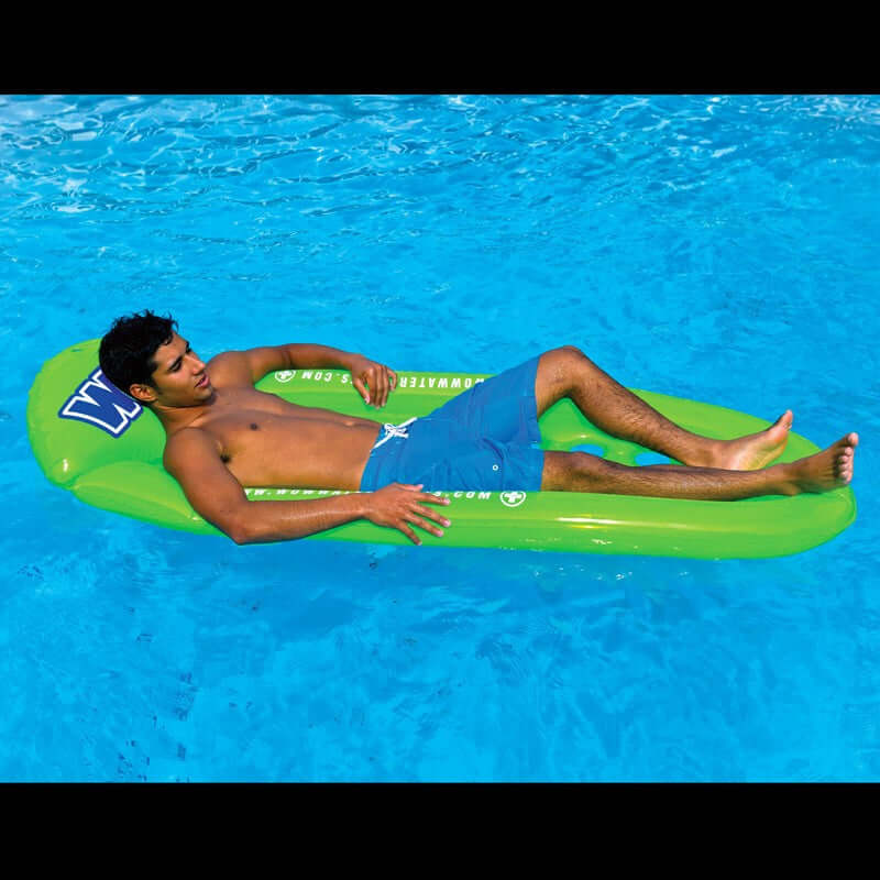 Man lying on a green inflatable pool float in a swimming pool