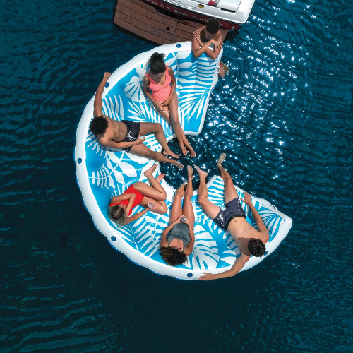 People on a circular inflatable raft with leaf patterns in the water