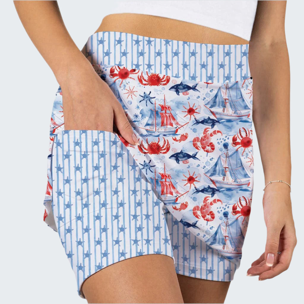 Close-up of a person wearing patterned shorts with red, blue, and white design on a light gray background