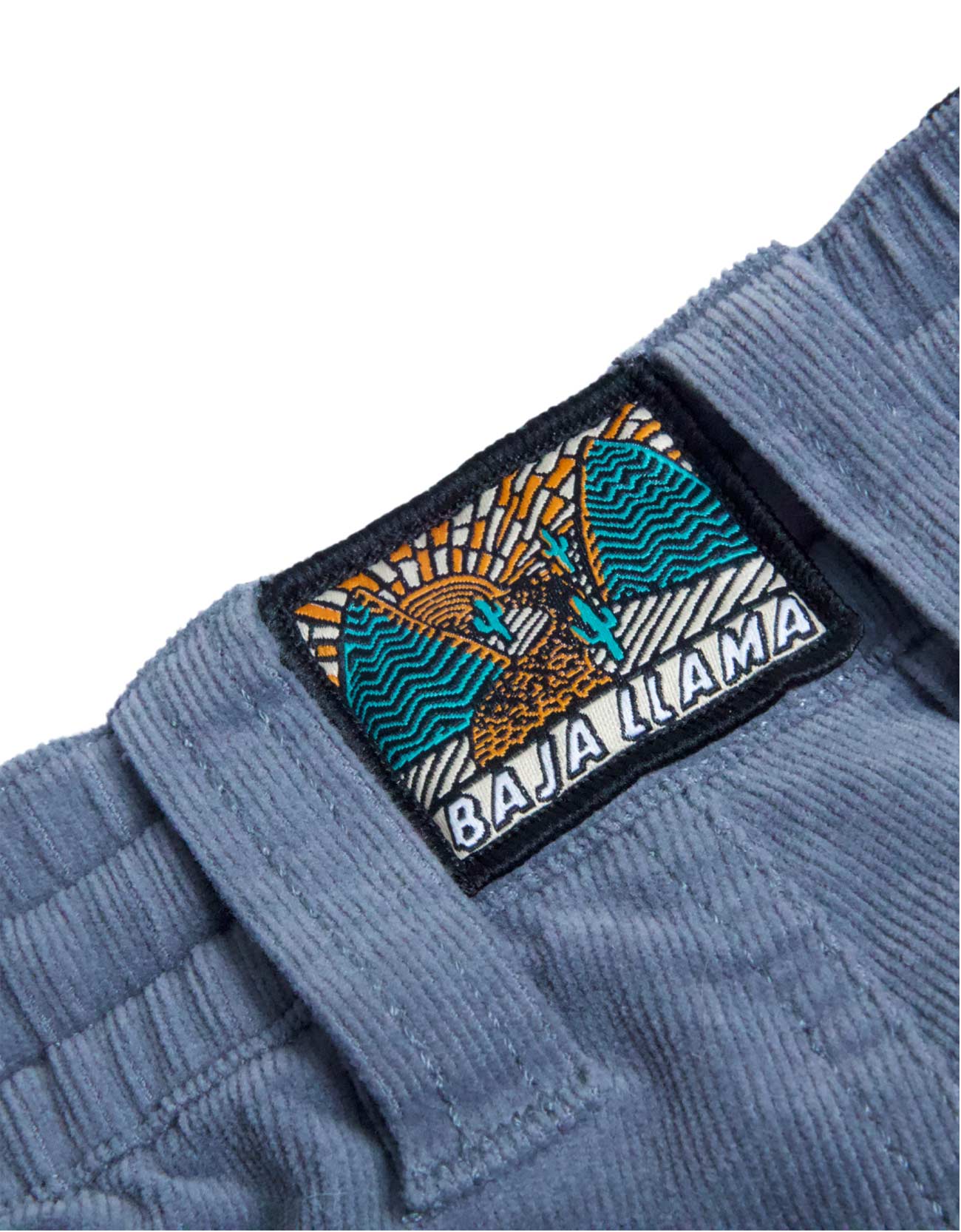 Close-up of a blue jacket with a 'Baja Llama' patch on a white background