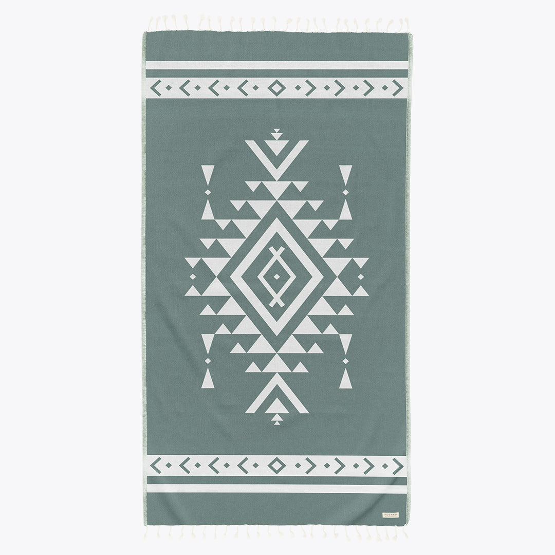 Green towel with white geometric pattern on a white background