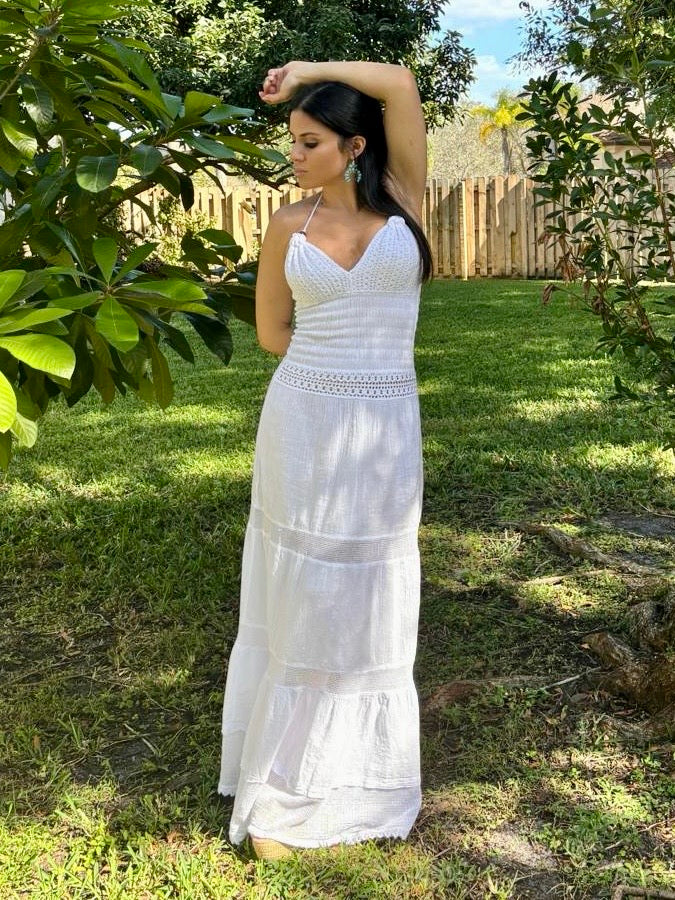 Woman in a white dress standing outdoors in a garden